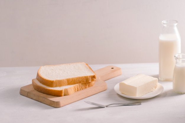 Gesneden brood bakken en boter op houten snijplank. Eenvoudig ontbijt