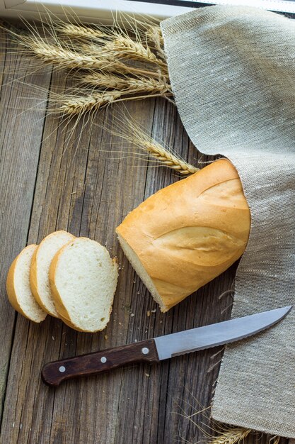 Gesneden brood met tarwearen op houten lijstclose-up