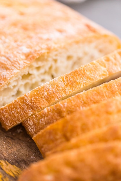 Gesneden brood van vers gebakken ciabattabrood op grijze tafel.