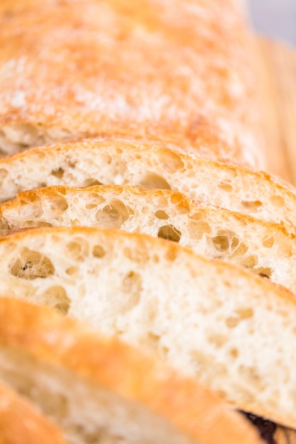 Gesneden brood van vers gebakken ciabattabrood op grijze tafel.