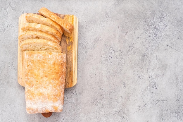 Gesneden brood van vers gebakken ciabattabrood op grijze tafel.