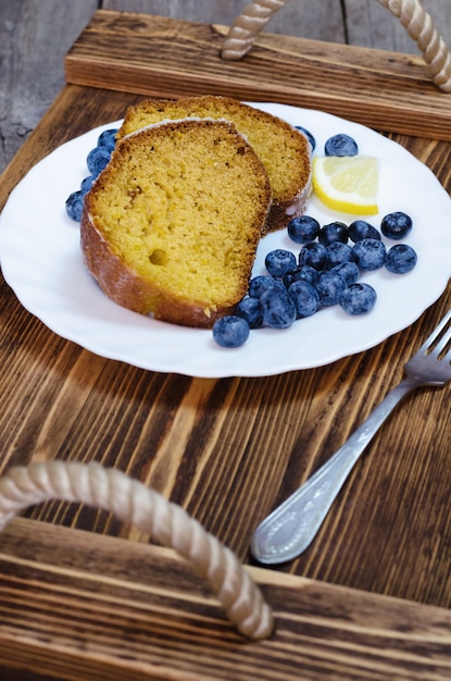 Gesneden citroencake met bosbessen op houten dienblad