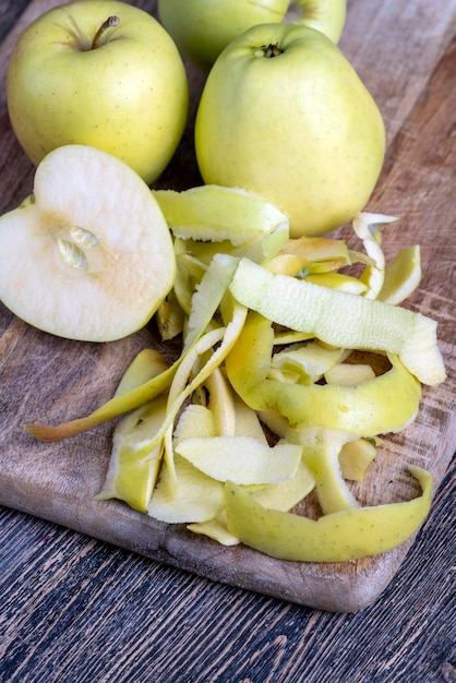 Gesneden en geschilde groene appel op een houten plank