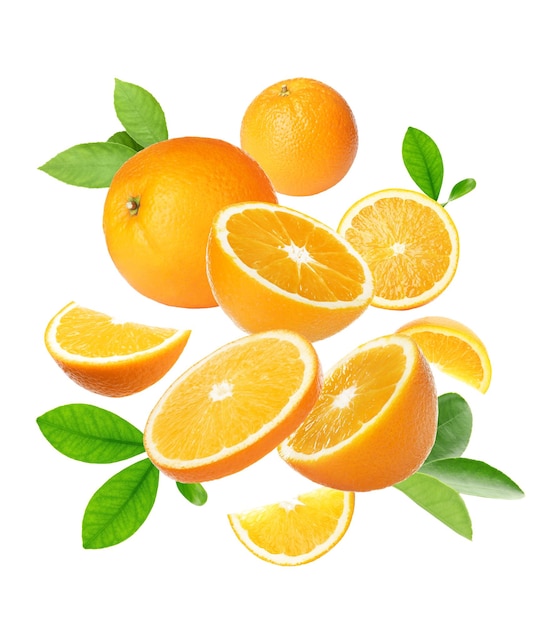 Gesneden en hele sinaasappelen met groene bladeren die op witte achtergrond vliegen