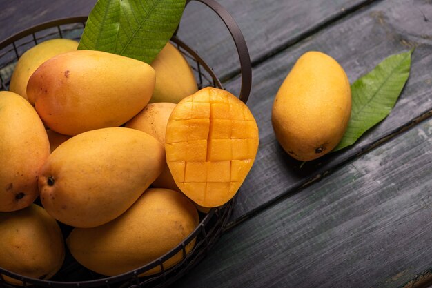Gesneden en intacte mango's op de donkere achtergrond