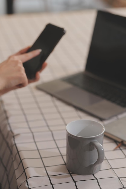 Gesneden foto van freelance zakenvrouw Aziatische vrouw met een koffiekop en bij het maken van planning analyse van het financieel verslag bedrijfsplan investering financiering analyse van de werkplaats