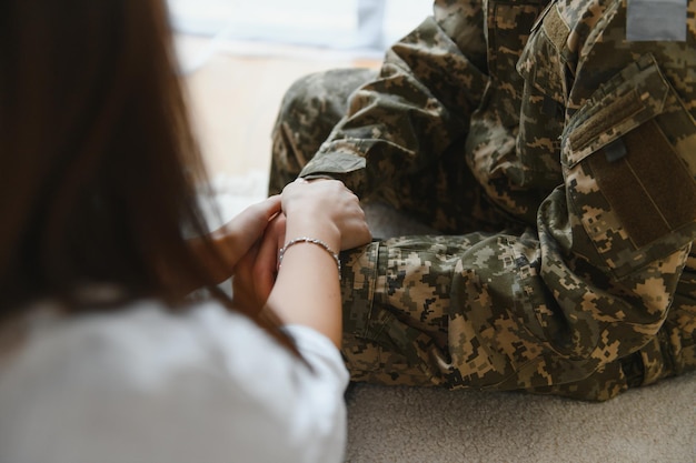 Gesneden foto van soldaat en psychiater die handen vasthouden tijdens een therapiesessie