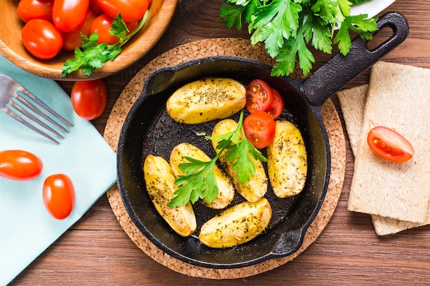 Gesneden gebakken aardappelen in een ijzeren koekenpan