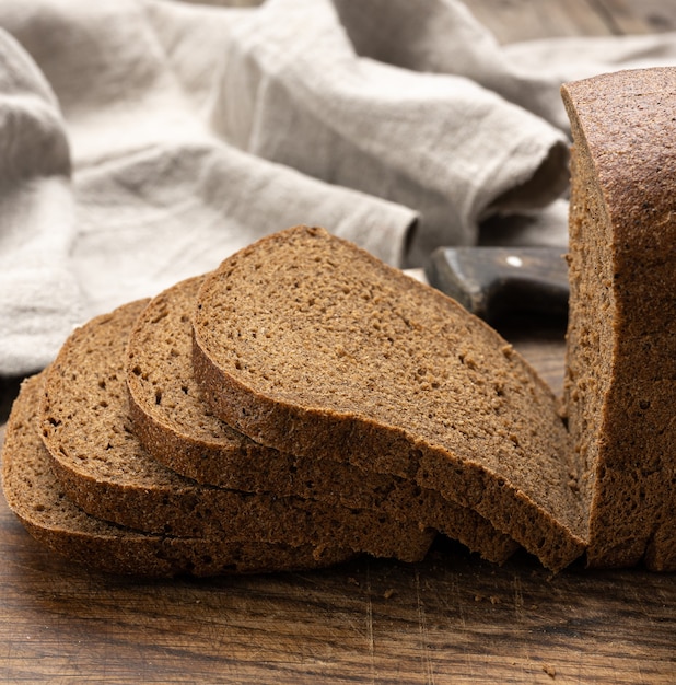 Gesneden gebakken rechthoekig brood van roggemeel op bruin bord, gezonde voeding, close-up