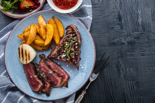 Gesneden gegrilde biefstuk. Biefstuk medium met aardappel en gebakken ui