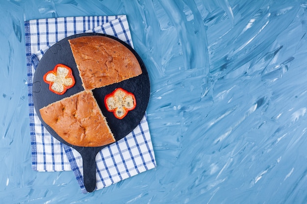 Gesneden geurig brood met peperplakken op zwarte scherpe raad.