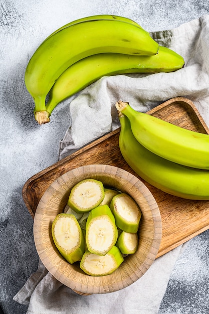 Gesneden groene banaan in een houten kom.