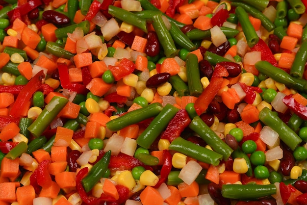 Gesneden groenten maïs bonen erwten wortelen paprika achtergrond