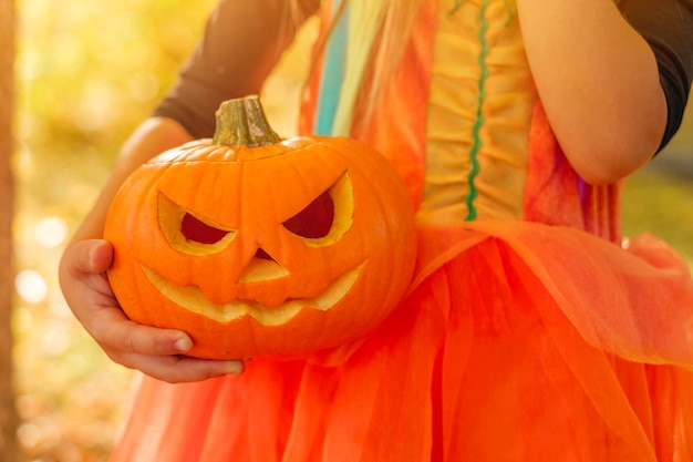 Gesneden Halloween-pompoen in de handen van een kind