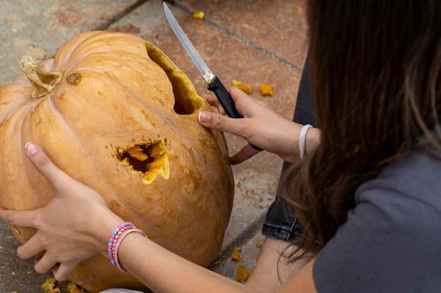 Gesneden Halloween-pompoenhefboomlantaarn met snijgereedschap Spookachtig lachend eng hoofd