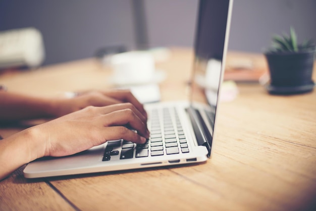 Foto gesneden hand met een laptop op het bureau