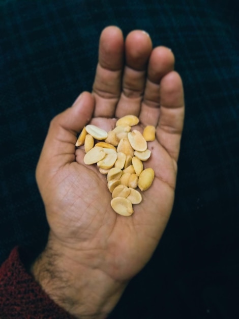 Gesneden hand met pinda's tegen een zwarte achtergrond