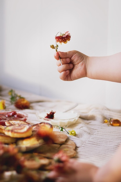 Foto gesneden hand van een kind dat een verwelkte bloem aan tafel houdt