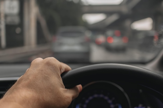 Gesneden hand van een man die een auto rijdt.