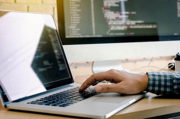 Foto gesneden hand van een man die een laptop op tafel gebruikt