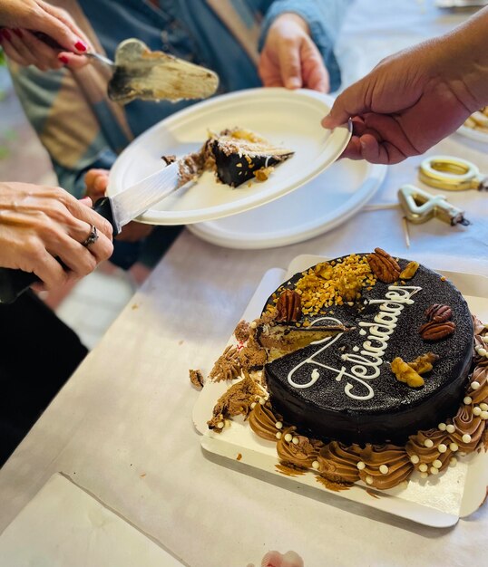 Foto gesneden hand van een man die eten bereidt op tafel verjaardagstaart