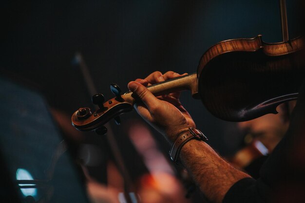 Foto gesneden hand van een man die tijdens een concert viool speelt