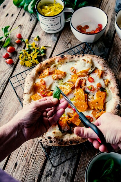 Foto gesneden hand van een persoon die voedsel op tafel bereidt