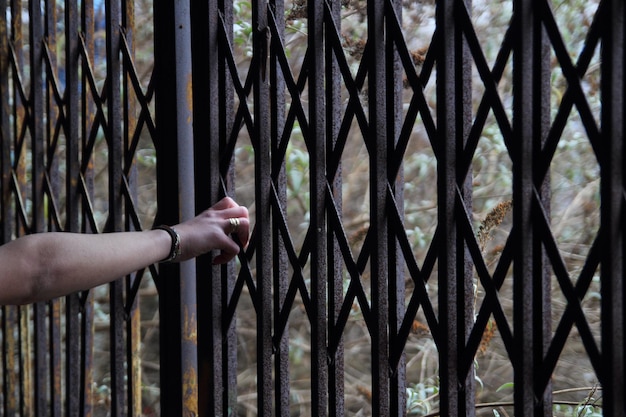 Foto gesneden hand van een vrouw die een hek vasthoudt