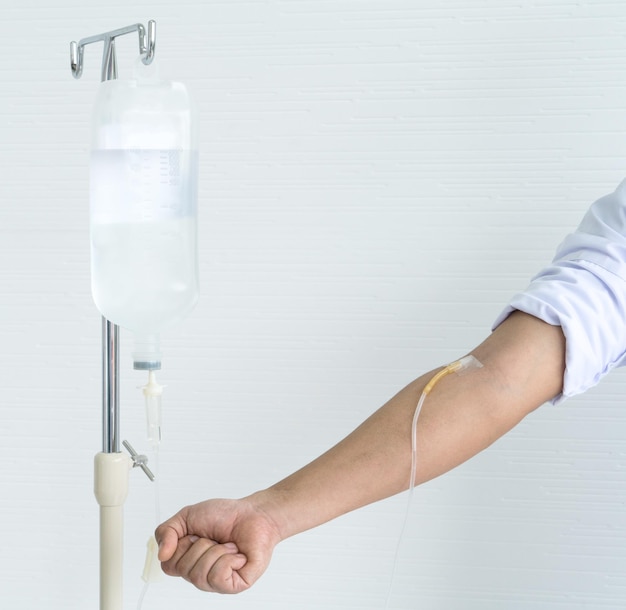 Gesneden hand van een vrouw met intraveneuze druppeling op een witte achtergrond