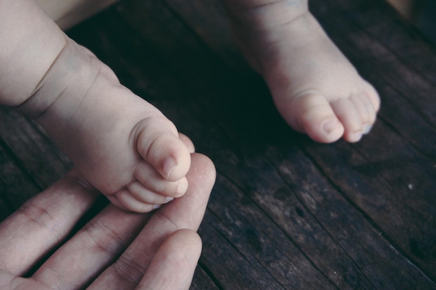 Gesneden hand van ouder die babypootjes vasthoudt