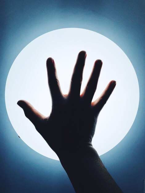Foto gesneden hand van persoon tegen verlichtingsapparatuur