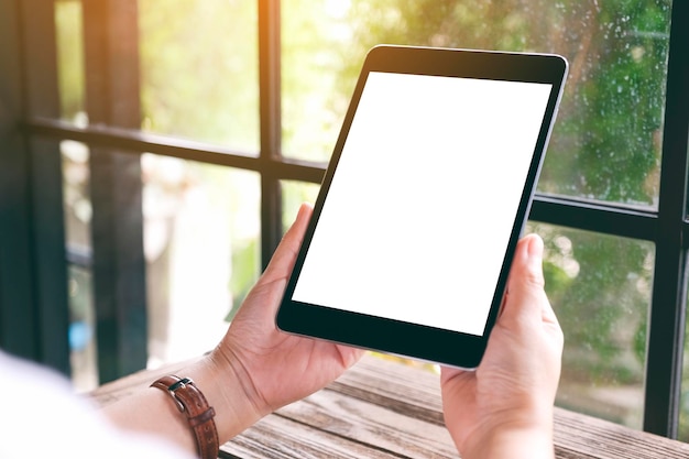 Gesneden handen met behulp van een lege digitale tablet aan tafel in een café