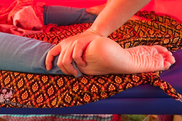 Foto gesneden handen van een massagetherapeut die een klant massageert op bed.