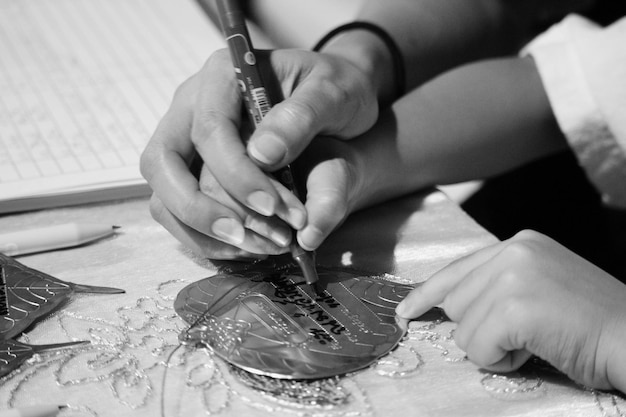 Foto gesneden handen van mensen die thuis op metalen blad schrijven