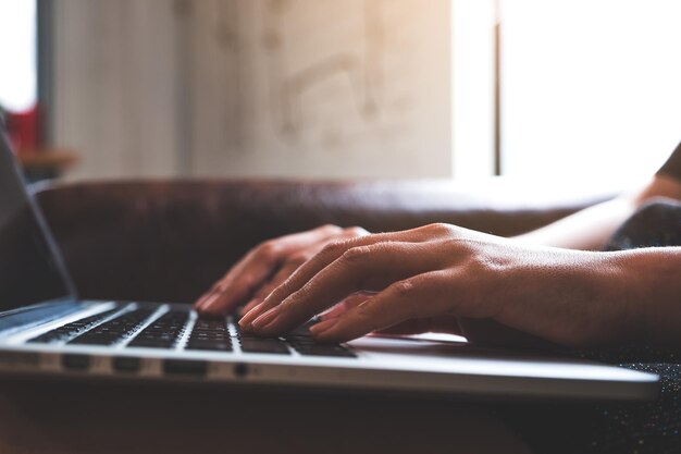 Foto gesneden handen van vrouw met laptop op tafel