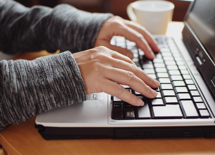 Foto gesneden handen van vrouw met laptop op tafel