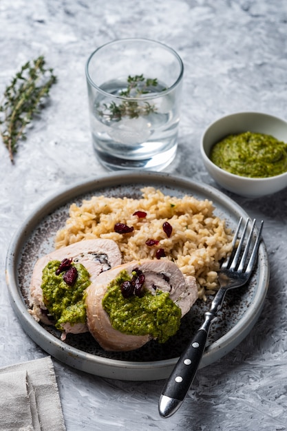 Gesneden kiprolletje met veenbessen, pesto en rijst.