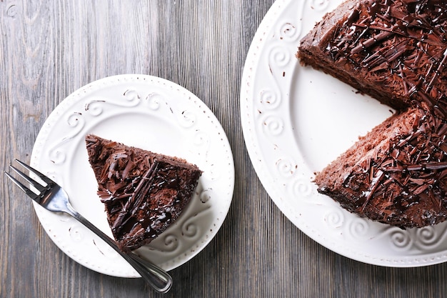 Gesneden lekkere chocoladetaart op houten tafel achtergrond