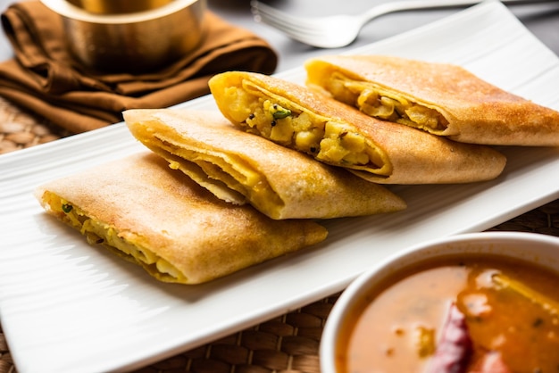 Gesneden Masala dosa of lentedosa is een Zuid-Indiase maaltijd geserveerd met sambhar en kokoschutney