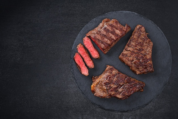 Gesneden medium rare gegrilde biefstuk op snijplank met rozemarijn en kruiden