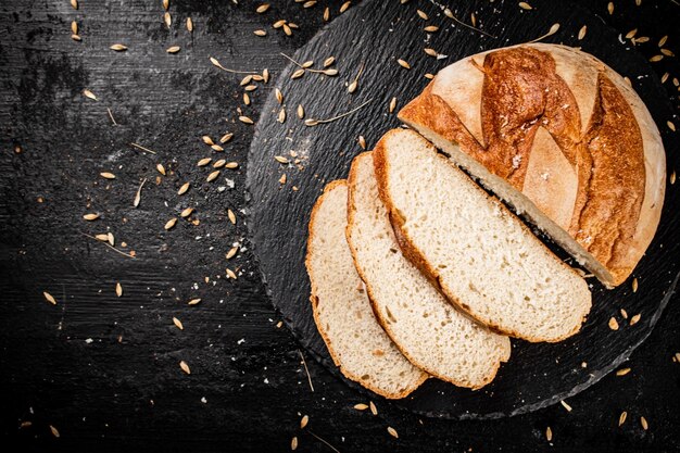 Gesneden op een stenen bord tarwebrood met granen