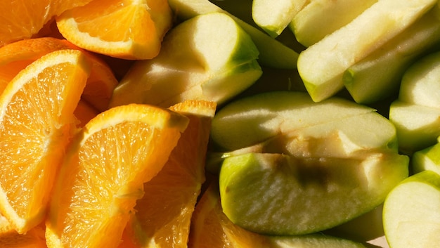 Gesneden oranje sappige sinaasappels en groene appels liggen naast elkaar bovenaanzicht horizontale banner met zomerfruit het concept van gezond eten