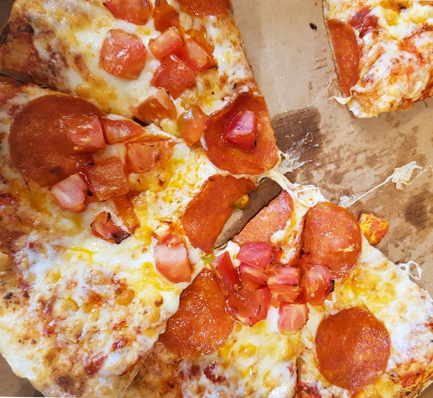 Gesneden pizza liggend in een kartonnen doos, bovenaanzicht