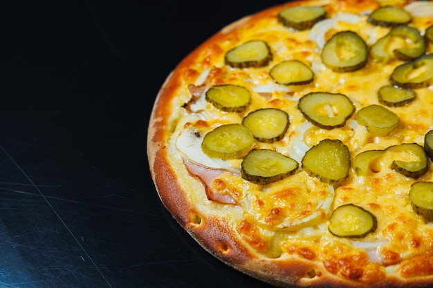 Gesneden pizza met komkommer en vlees tomatensaus mozzarella ui en rand van deeg gevuld met roomkaas op een zwarte achtergrond