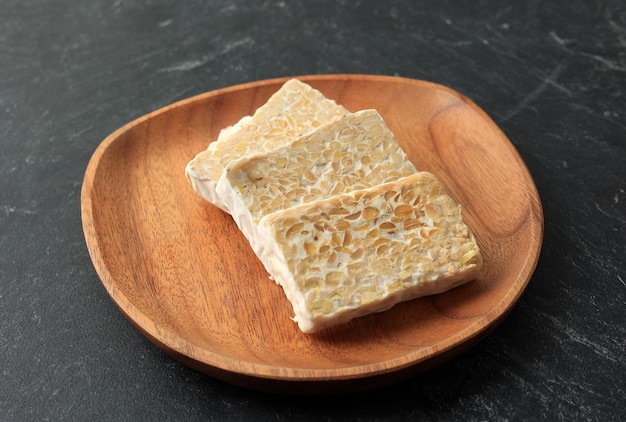 Gesneden rauwe tempe of tempeh op houten plaat