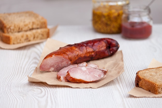 Gesneden rookworst in een houten tafel met brood en ketchup.