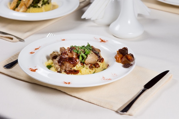 Gesneden rosbief met kruiden, hartige rijst en groenten geserveerd op een tafel in een restaurant voor een smakelijke maaltijd