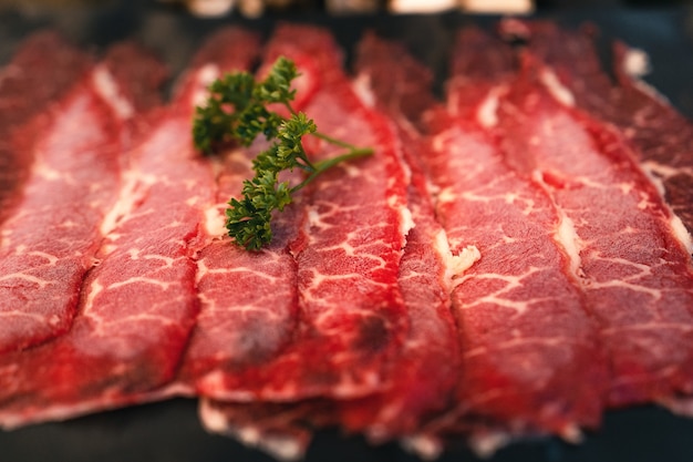 Gesneden rundvlees shabu in een zwarte plaat in een restaurant, Japans gesneden rundvlees