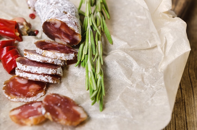 Gesneden salami met rozemarijn en chili peper.