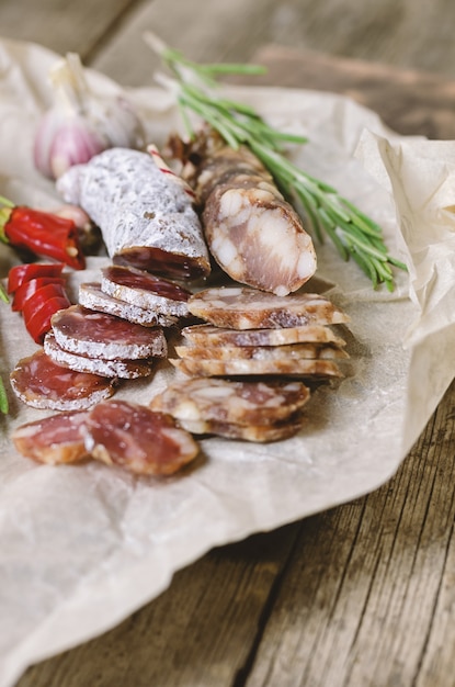 Gesneden salami met rozemarijn en chili peper.